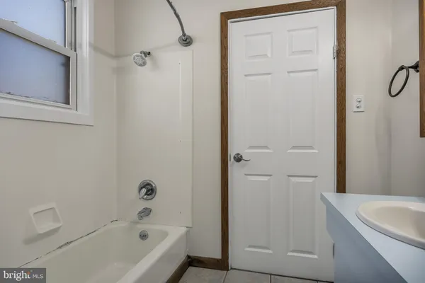 a bathroom with a tub a sink and a shower