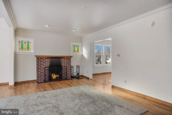 an empty room with windows and fireplace