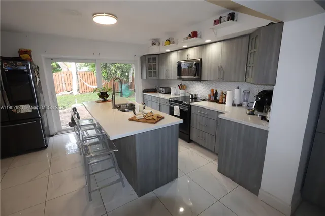 a kitchen with a sink a counter top space appliances and cabinets