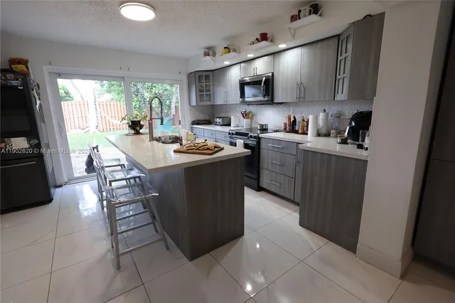 a kitchen with sink a microwave a stove and refrigerator