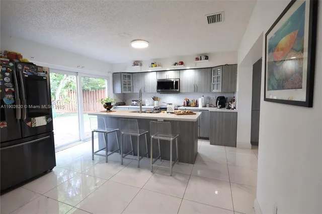 a kitchen with a sink a counter top space cabinets and stainless steel appliances
