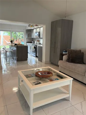 a kitchen with a stove a refrigerator and a view living room