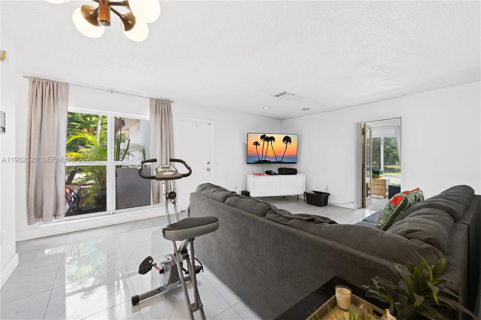 10610 Southwest 128th Avenue Miami, FL 33186 - Photo 26 of 46 a living room with furniture a window and a flat screen tv