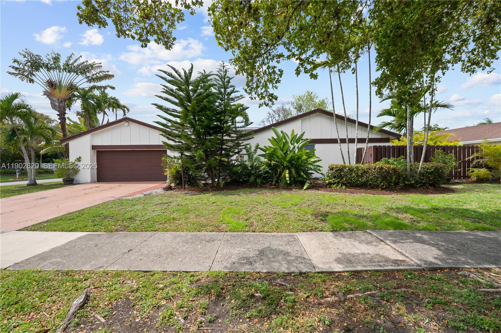 10610 Southwest 128th Avenue Miami, FL 33186 - Photo 7 of 46 a front view of a house with a yard and a garage