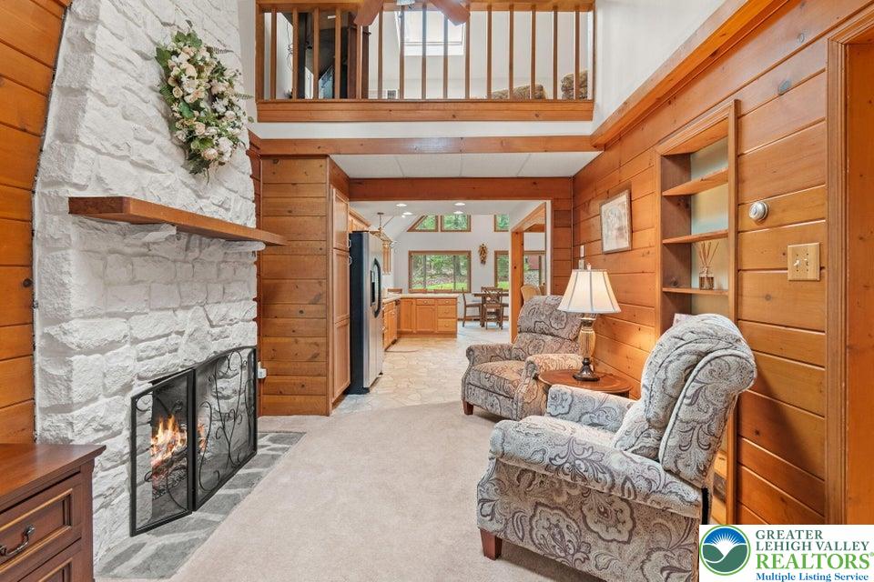 15 Hazard Run Road Lake Harmony, PA 18624 - Photo 16 of 48 a living room with furniture a fireplace and a floor to ceiling window