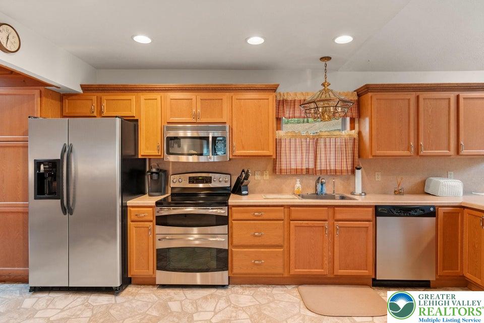 15 Hazard Run Road Lake Harmony, PA 18624 - Photo 10 of 48 a kitchen with stainless steel appliances granite countertop a refrigerator a sink a stove with wooden cabinets