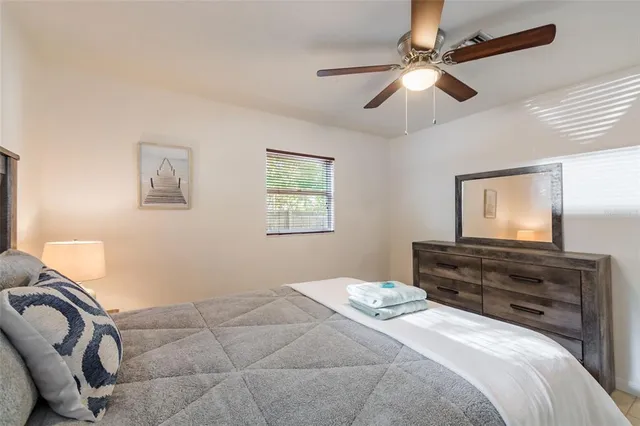 a bedroom with a bed and dresser with mirror