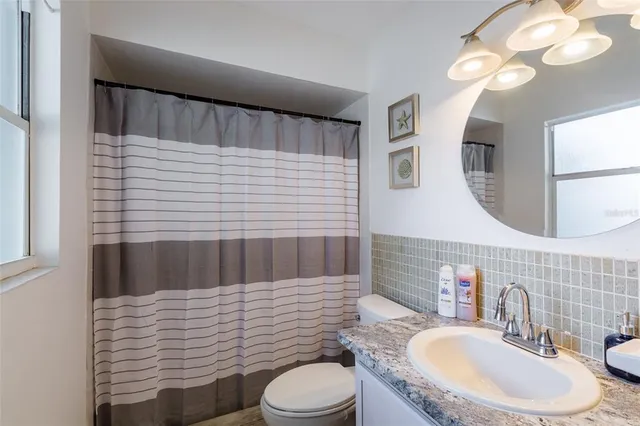 a bathroom with a sink a toilet and mirror