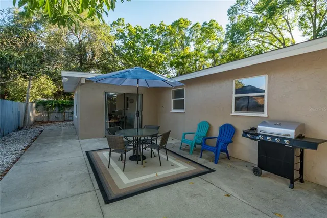 a patio with wooden table and chairs