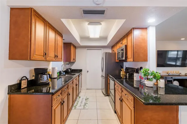a kitchen with stainless steel appliances granite countertop sink stove top oven and cabinets