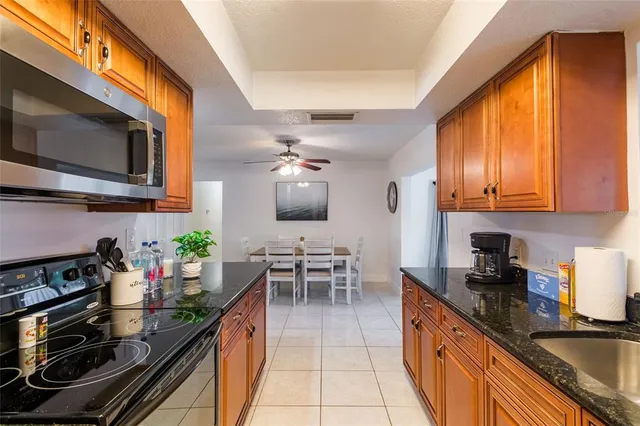 a kitchen with stainless steel appliances granite countertop a sink stove and microwave