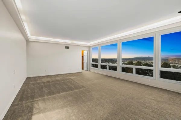 a view of an empty room with a fireplace and large window