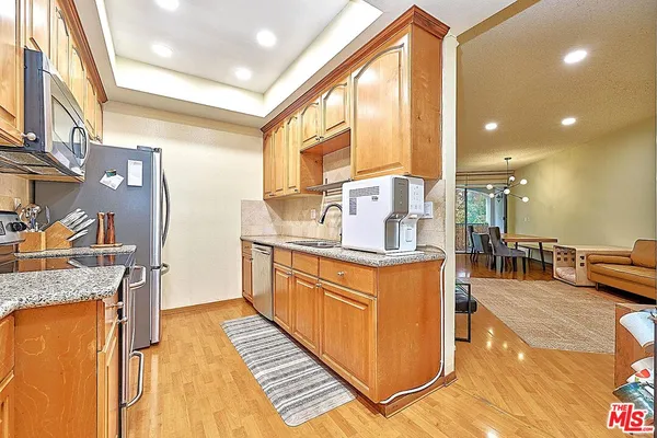 a kitchen with stainless steel appliances granite countertop a sink and a stove