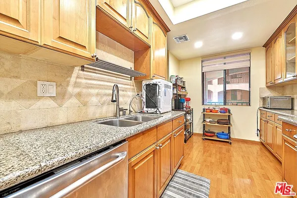 a kitchen view with granite countertop a sink and cabinets
