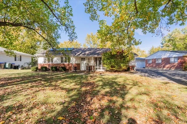 a view of a big yard with large trees and plants