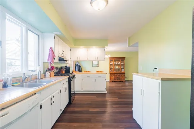a large white kitchen with wooden floors and white walls