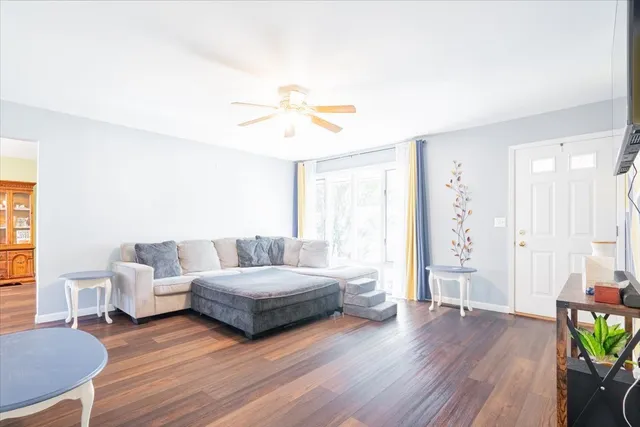 a living room with furniture and a wooden floor