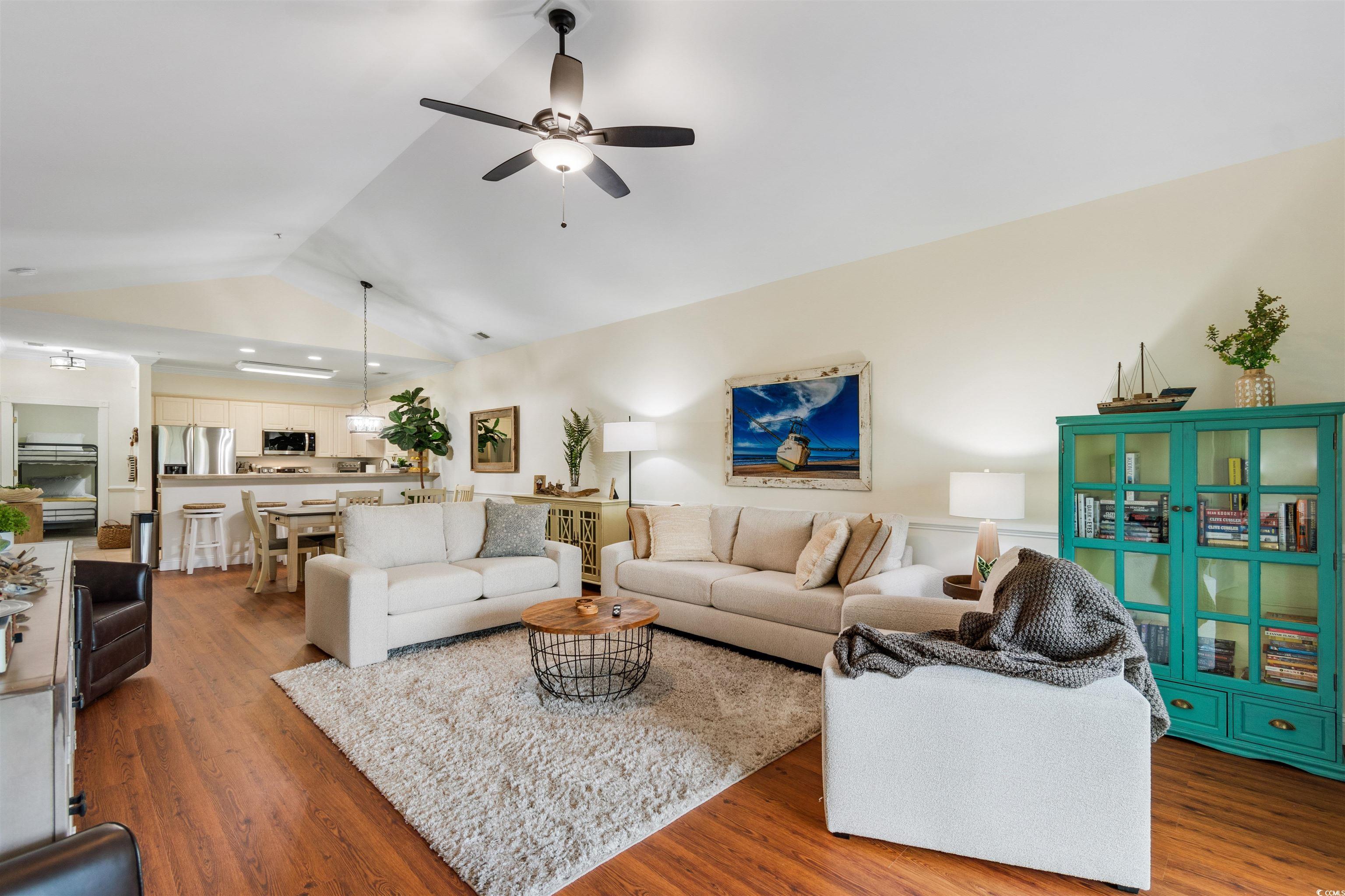 4843 Luster Leaf Circle, Unit 402 Myrtle Beach, SC 29577 - Photo 8 of 33 Living area with lofted ceiling, wood finished floors, and ceiling fan