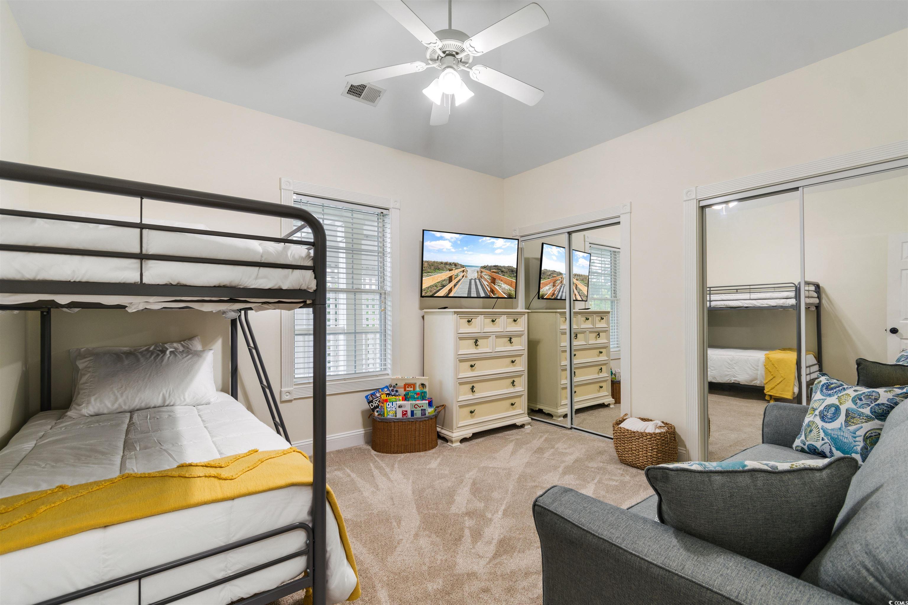 4843 Luster Leaf Circle, Unit 402 Myrtle Beach, SC 29577 - Photo 10 of 33 Bedroom with two closets, light carpet, and ceiling fan