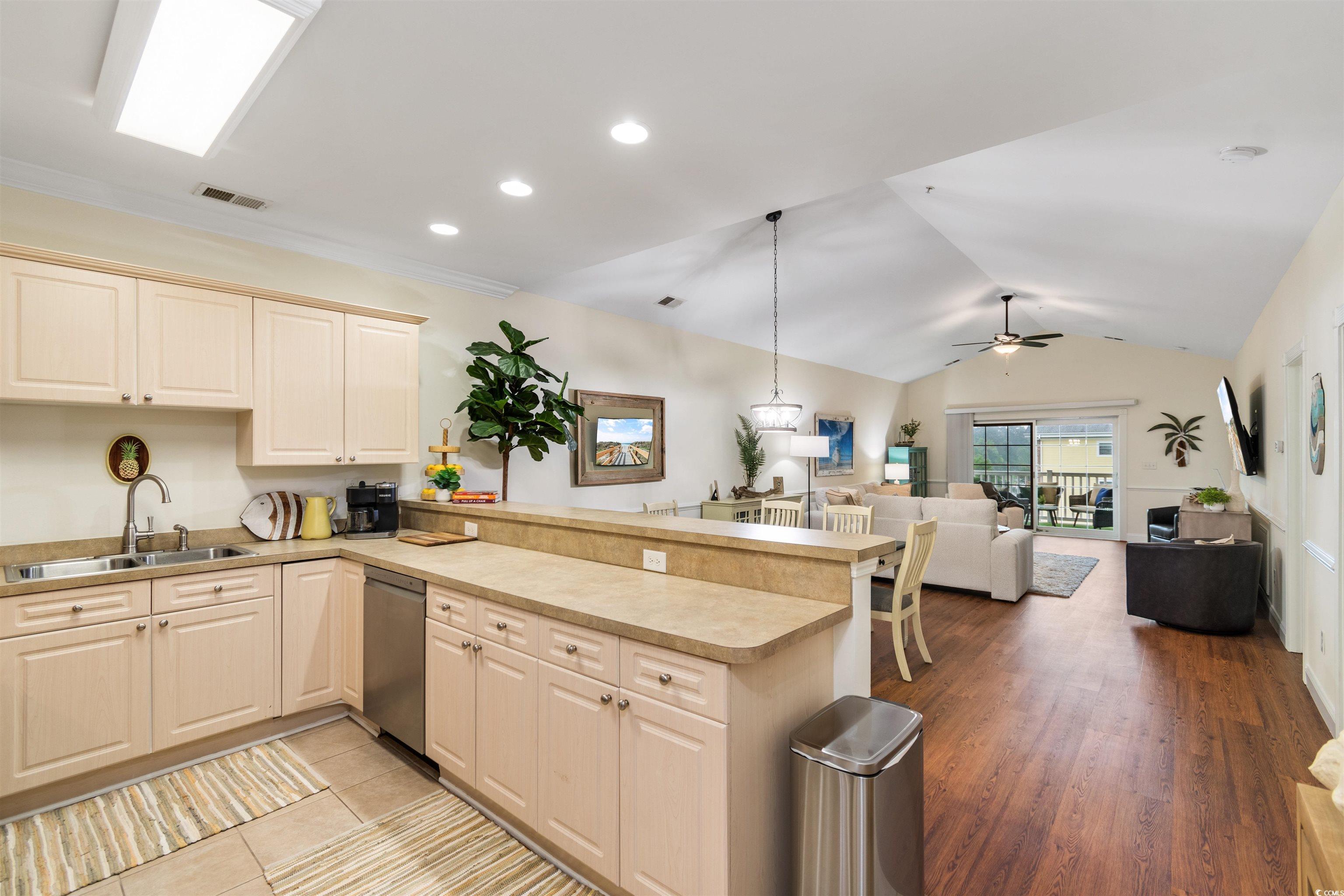 4843 Luster Leaf Circle, Unit 402 Myrtle Beach, SC 29577 - Photo 31 of 33 Kitchen with pendant lighting, open floor plan, light countertops, lofted ceiling, and a peninsula