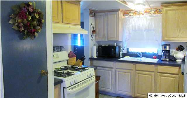 34 Roberts Road Toms River, NJ 08755 - Photo 9 of 14 a kitchen with a stove a sink and a microwave