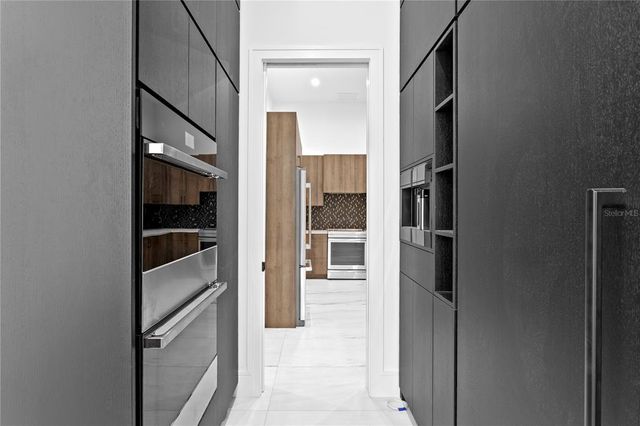 a kitchen with a stove a sink a center island and windows