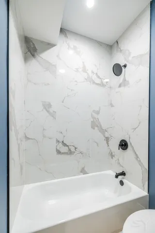 a bathroom with a bathtub and shower