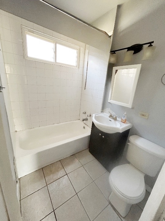 11833 South Perry Avenue Chicago, IL 60628 - Photo 4 of 8 a spacious bathroom with a bathtub sink and toilet