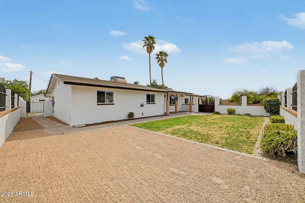 a view of a house with a backyard and a tree
