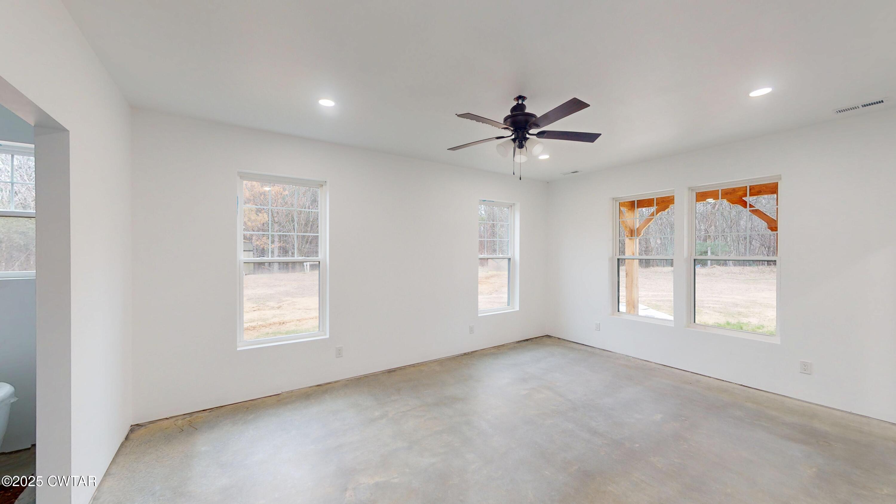 3140 Rowland Mill Road Buena Vista, TN 38318 - Photo 15 of 34 an empty room with chandelier fan and windows