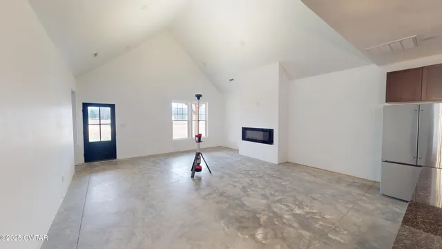 a kitchen with granite countertop a stove a sink a refrigerator and blue cabinets with wooden floor