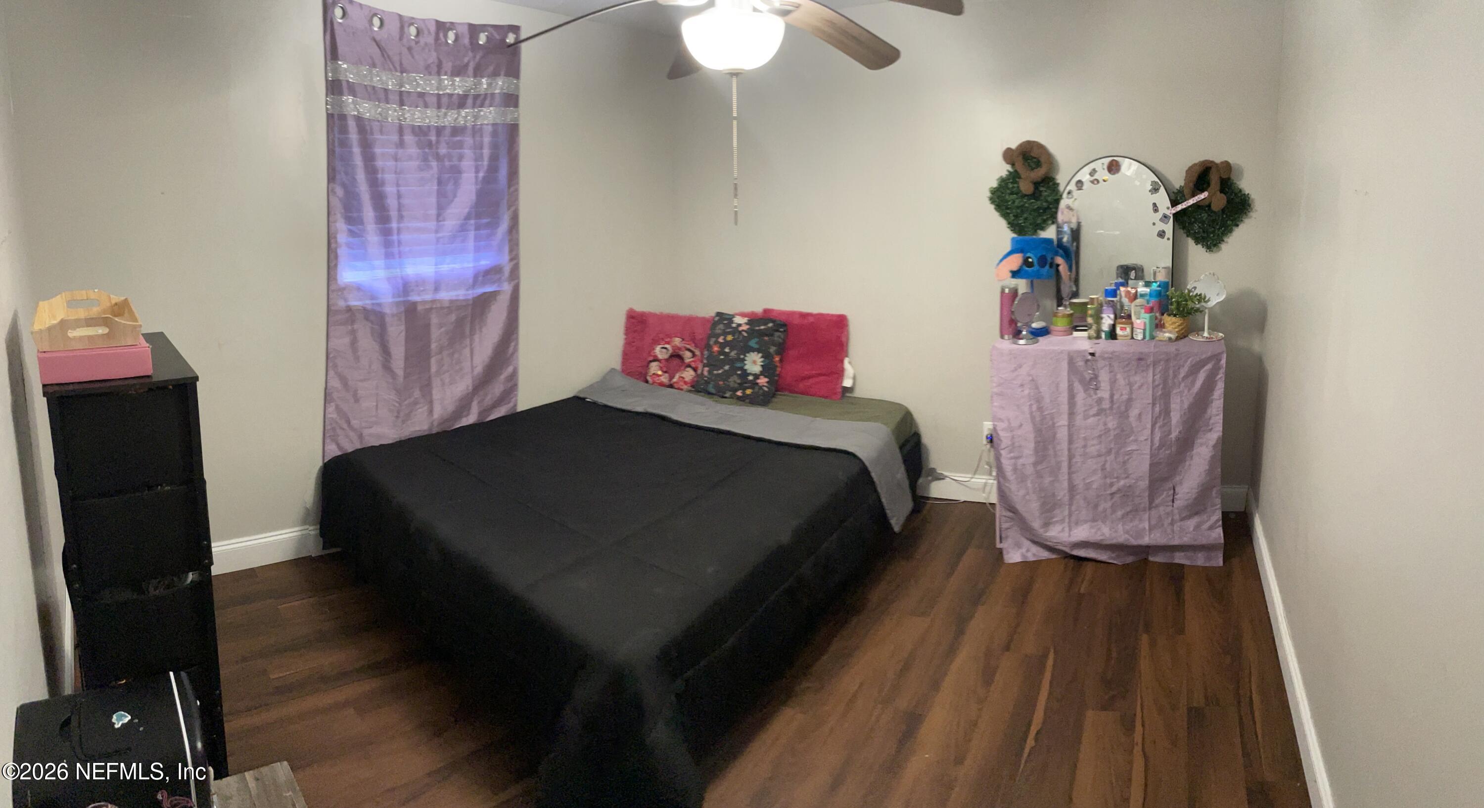 5884 Retha Road Jacksonville, FL 32254 - Photo 11 of 16 a bedroom with a bed and a flat tv screen on a dresser