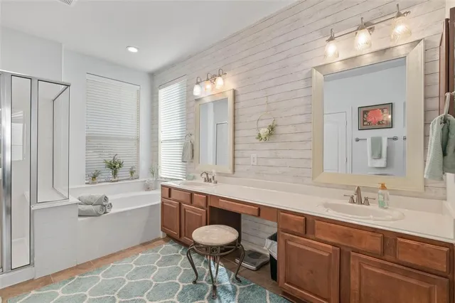 a bathroom with a double vanity sink a mirror and a bathtub