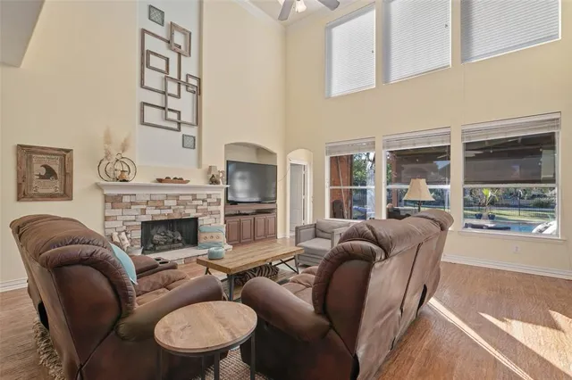a living room with furniture a fireplace and a large window
