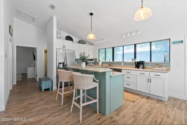 a large kitchen with kitchen island granite countertop a large window and stainless steel appliances