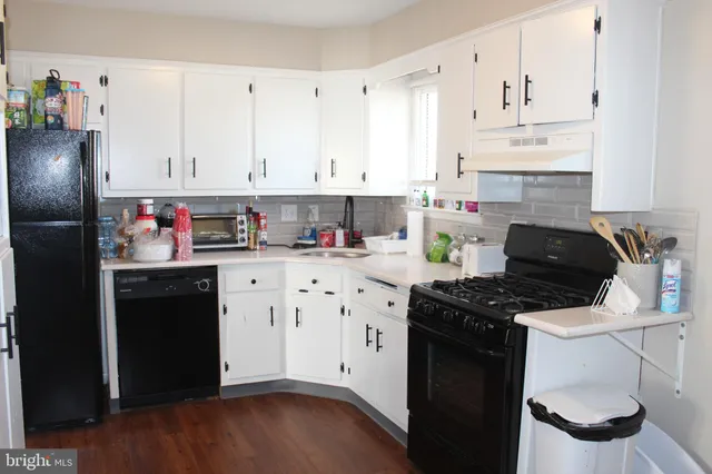 a kitchen with stainless steel appliances a white cabinets and a stove top oven