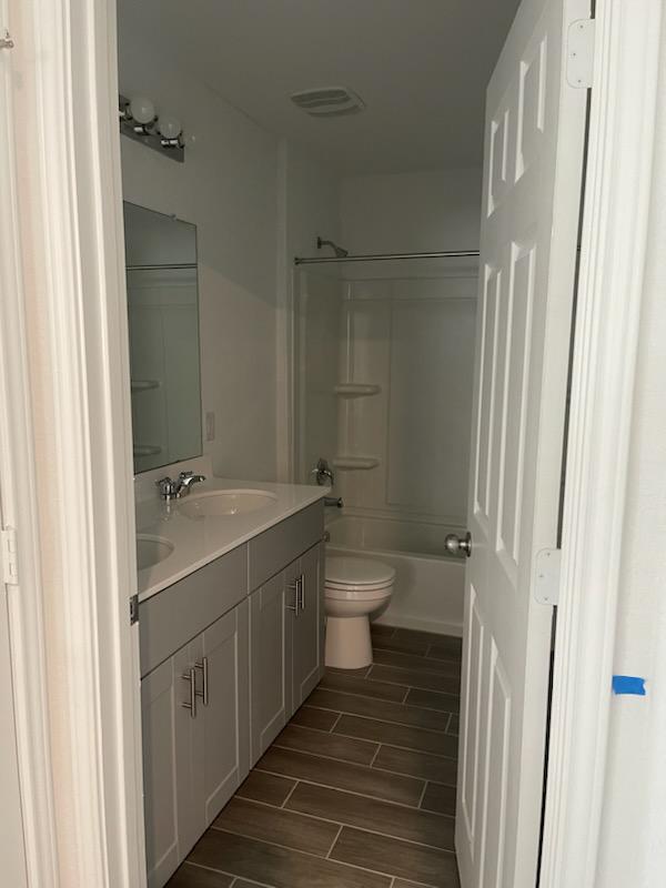 1509 Hope Rnch Road Leander, TX 78641 - Photo 19 of 25 Bathroom featuring vanity, toilet, wood finish floors, and shower / bathtub combination
