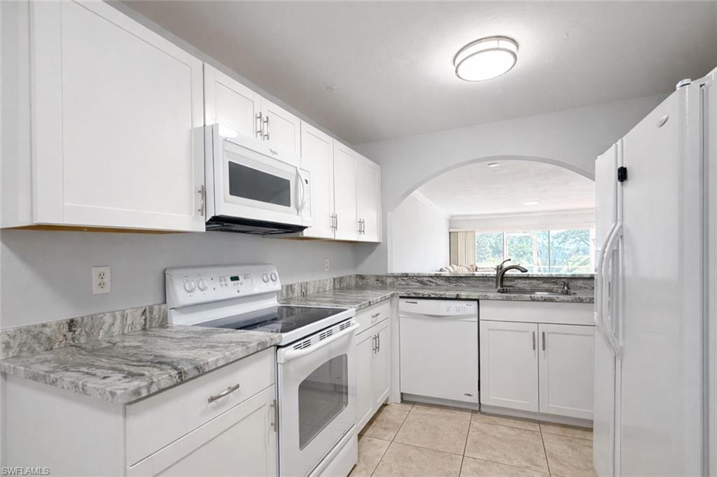 534 Augusta Boulevard, Unit E104 Naples, FL 34113 - Photo 1 of 26 a kitchen with stainless steel appliances granite countertop white cabinets sink and stove