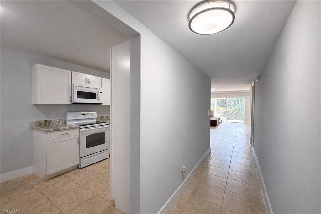 534 Augusta Boulevard, Unit E104 Naples, FL 34113 - Photo 13 of 26 a kitchen with cabinets stainless steel appliances and a window