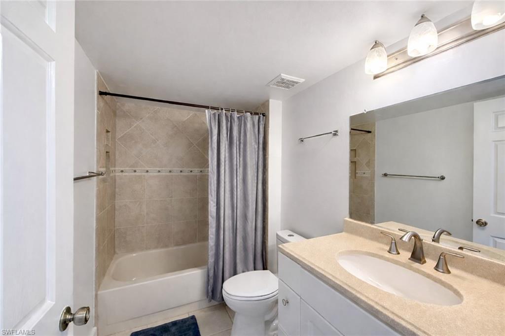 534 Augusta Boulevard, Unit E104 Naples, FL 34113 - Photo 20 of 26 a bathroom with a sink toilet and shower