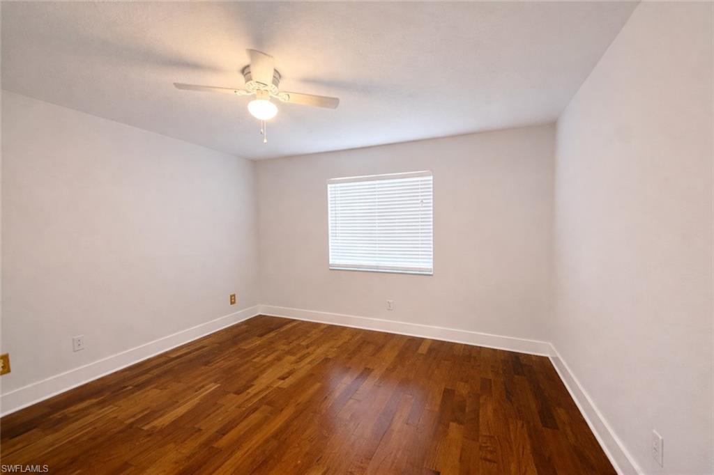 534 Augusta Boulevard, Unit E104 Naples, FL 34113 - Photo 21 of 26 wooden floor in an empty room with a window