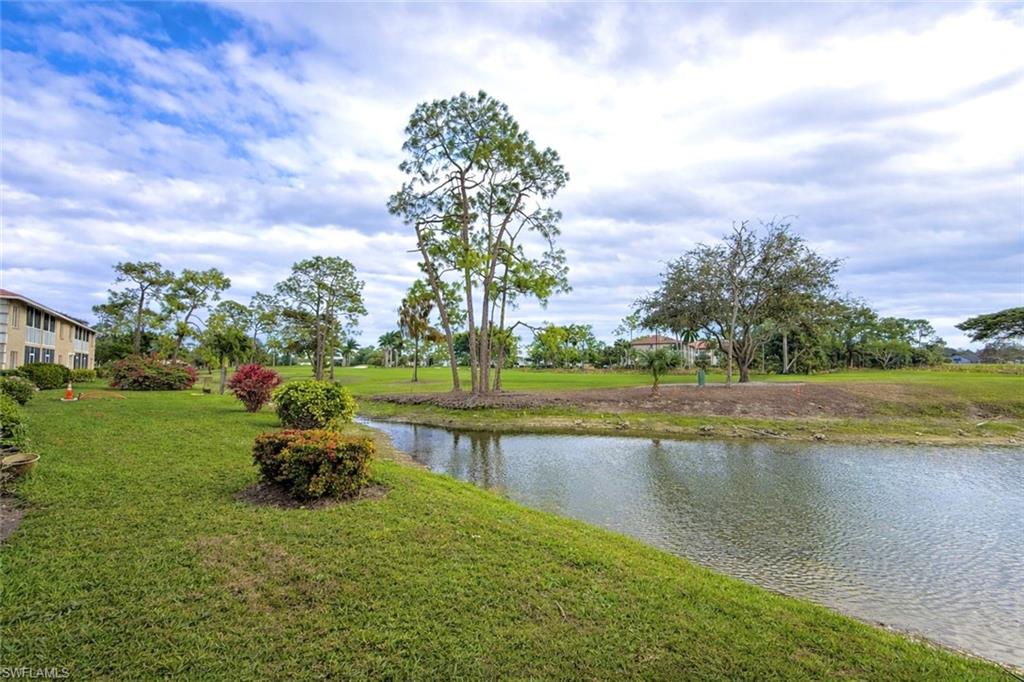 534 Augusta Boulevard, Unit E104 Naples, FL 34113 - Photo 24 of 26 a view of a lake with houses in the back