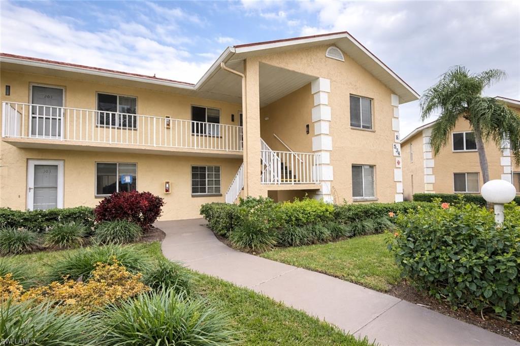534 Augusta Boulevard, Unit E104 Naples, FL 34113 - Photo 3 of 26 a front view of a house with a yard