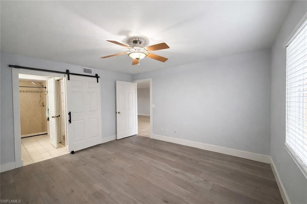 534 Augusta Boulevard, Unit E104 Naples, FL 34113 - Photo 9 of 26 wooden floor in an empty room with a window