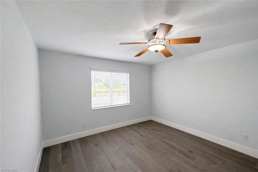 534 Augusta Boulevard, Unit E104 Naples, FL 34113 - Photo 10 of 26 an empty room with wooden floor ceiling fan and window