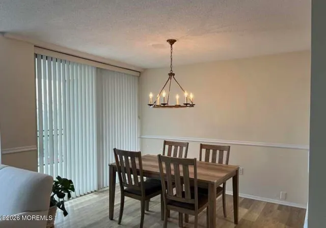 a view of a dining room with furniture wooden floor and chandelier