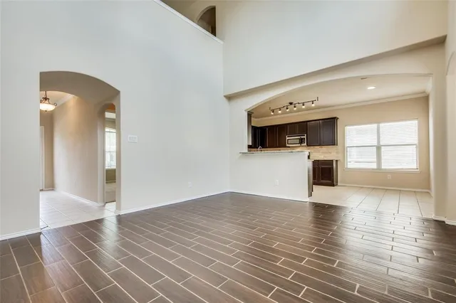 a view of a hallway with wooden floor and a kitchen