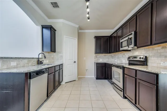 a kitchen with stainless steel appliances granite countertop a sink stove and cabinets