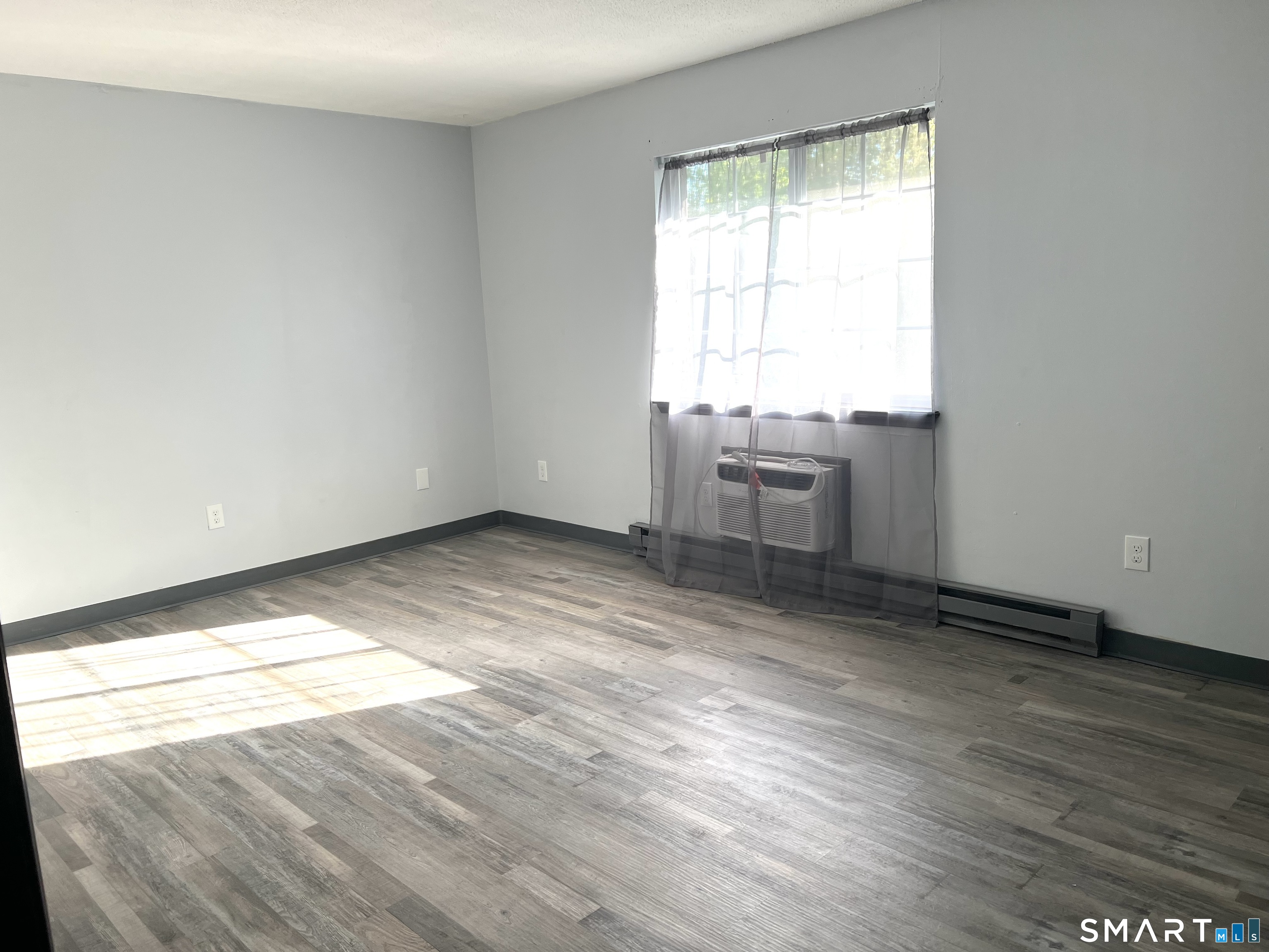 35 Mountain Village Road, Unit 30 Waterbury, CT 06706 - Photo 3 of 15 Living room recently painted, new laminate floor, and new wall A/C