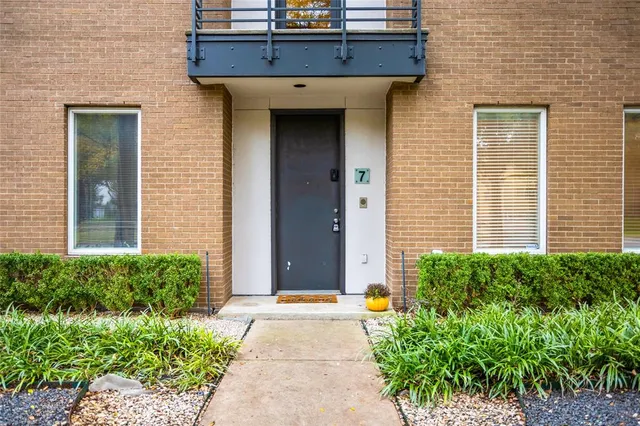 a view of a brick house with potted plants